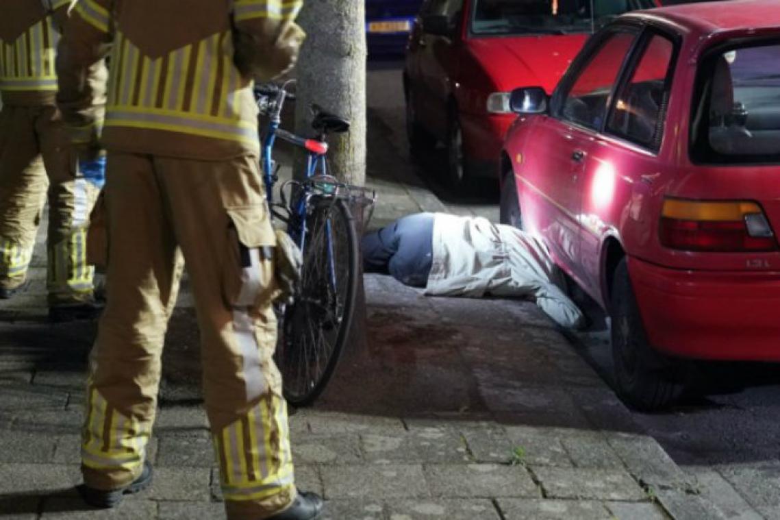 Man komt met hoofd tussen stoeprand en auto vast te zitten