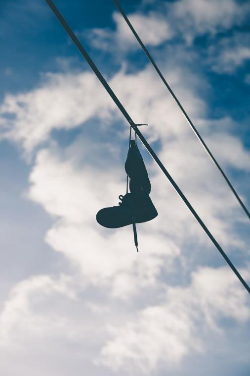 Waarom mensen schoenen over een elektriciteitsdraad hangen