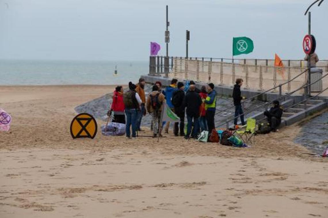 Extinction Rebellion tekent zandloperlogo op strand Oostende