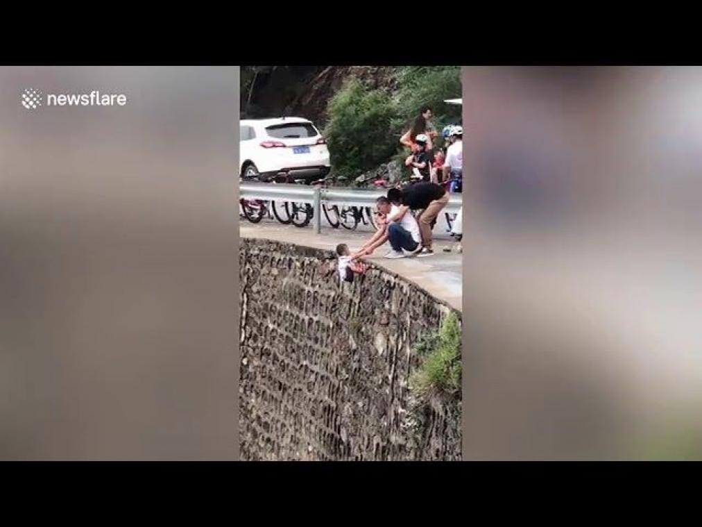 Roekeloze vader laat kind boven afgrond hangen om perfecte foto te maken (video)