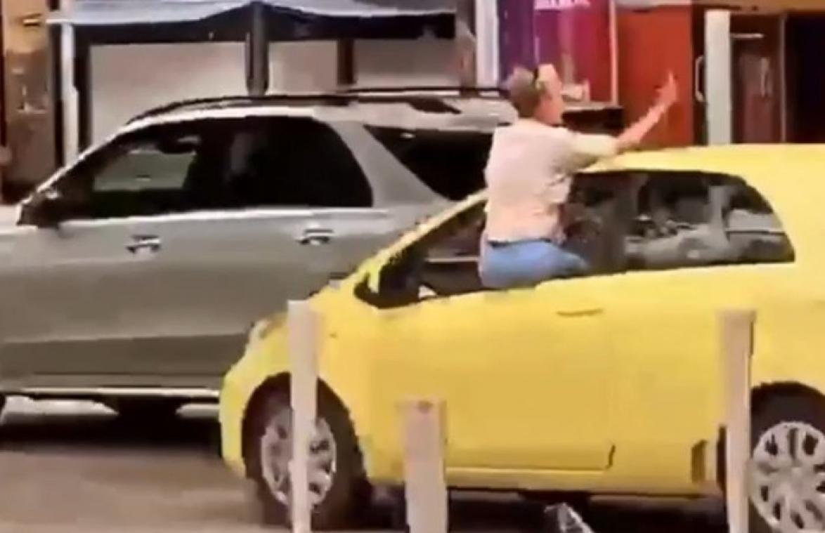 Vrouw hangt uit autoraam en steekt middelvinger op, maar let niet goed op de weg... (video)