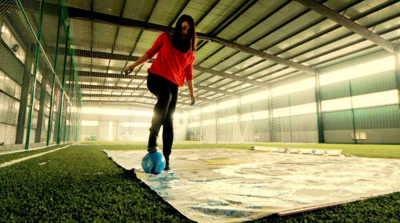Kunstenares schildert portret van Messi, Ronaldo en Neymar met een voetbal en haar voeten
