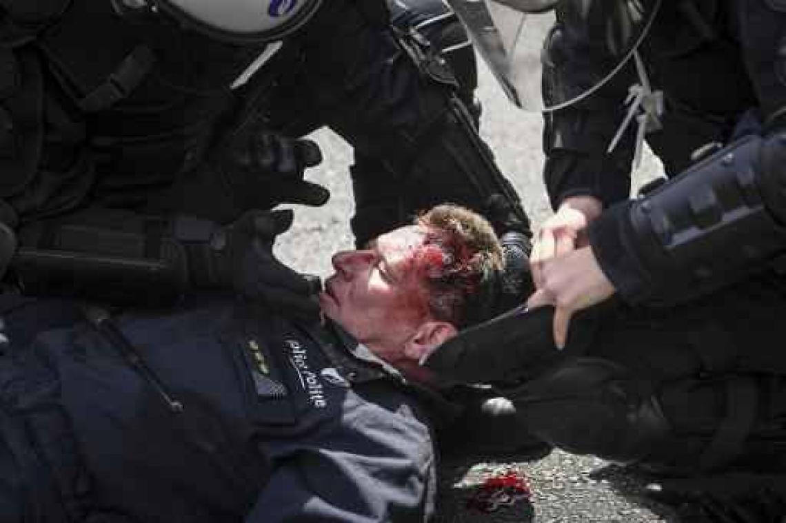 Nationale betoging - Rode relschopper slaat politiecommissaris knock-out