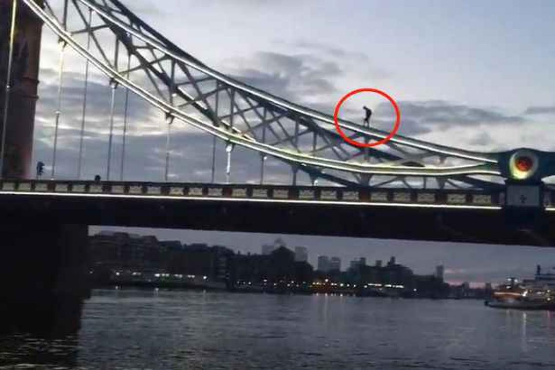 Man klimt op Tower Bridge  om foto's te trekken