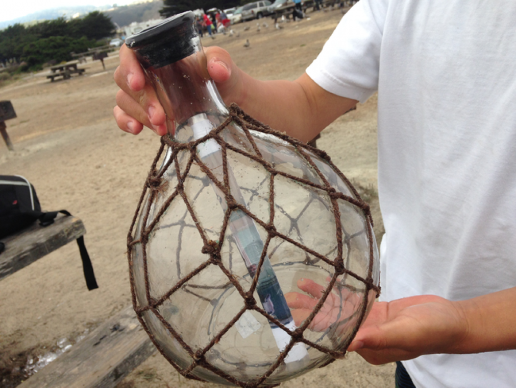 Een groepje vrienden vindt een authentieke boodschap in een fles aan het strand.