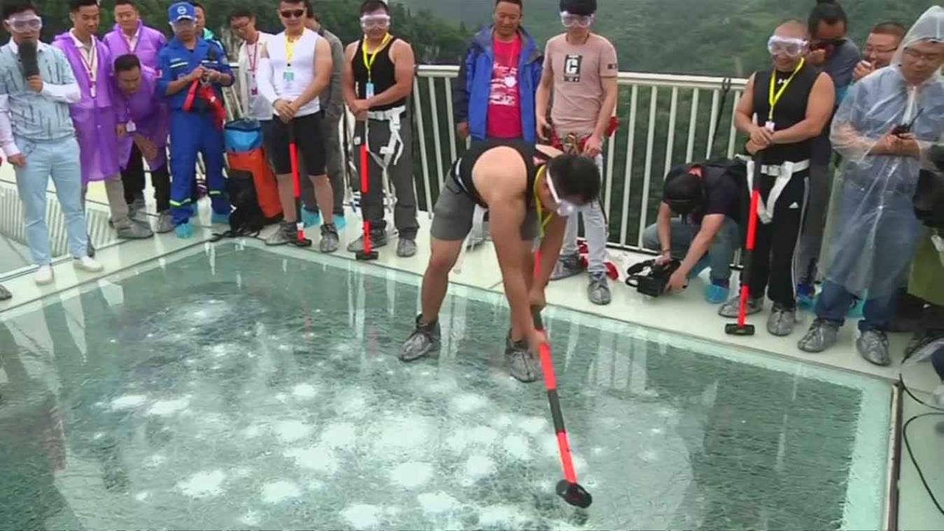 Chinezen testen glazen brug met voorhamer