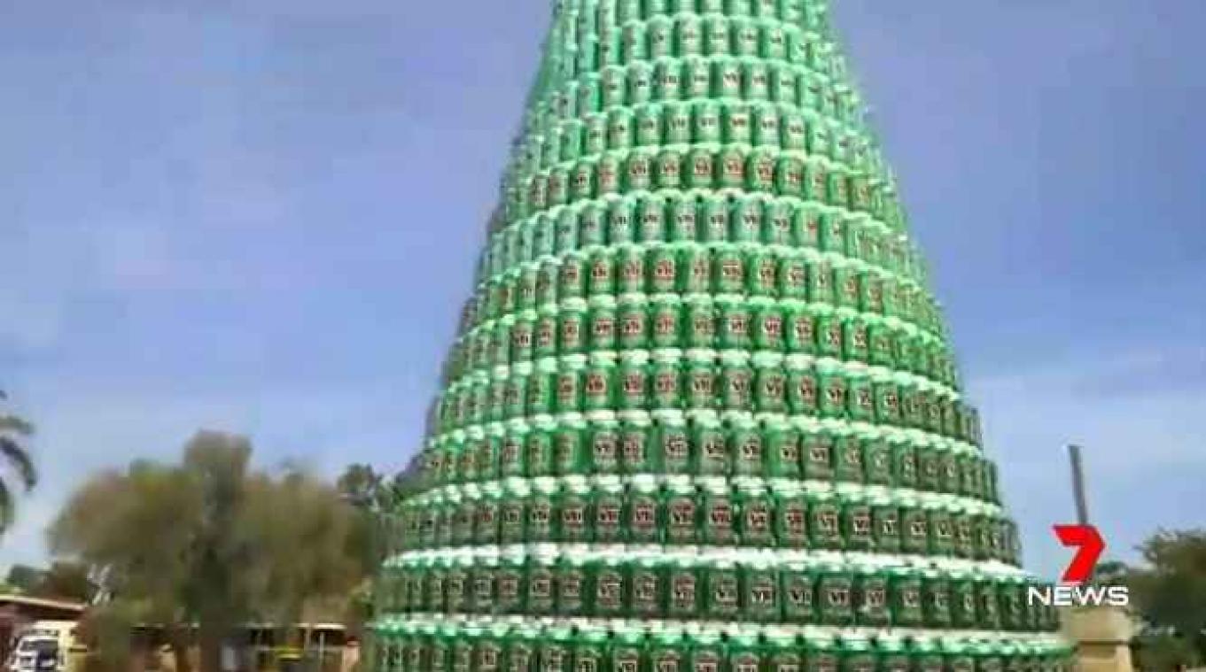 Man maakt kerstboom uit bierblikjes