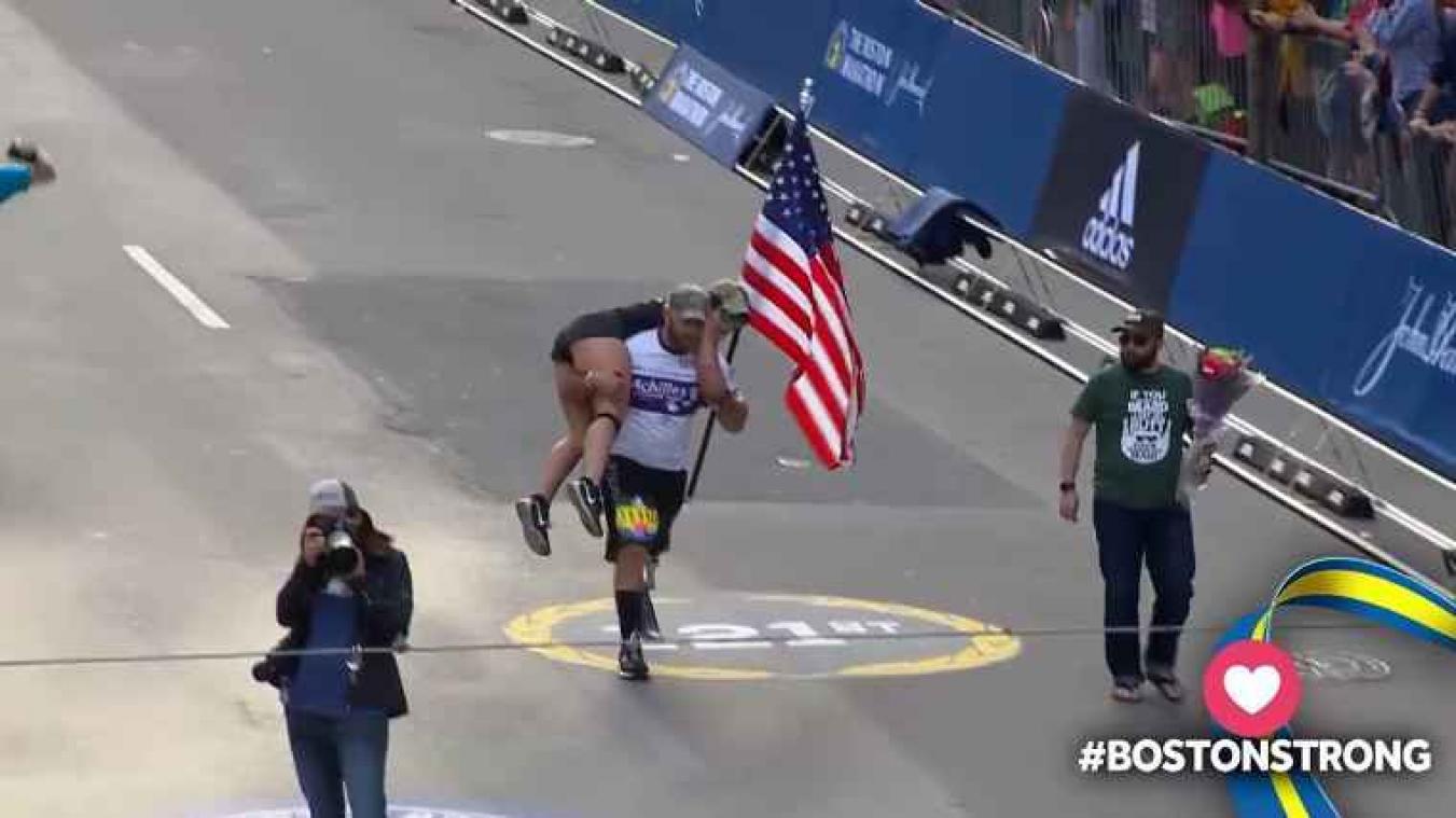 Marathonloper met beenprothese draagt vrouw over de finish