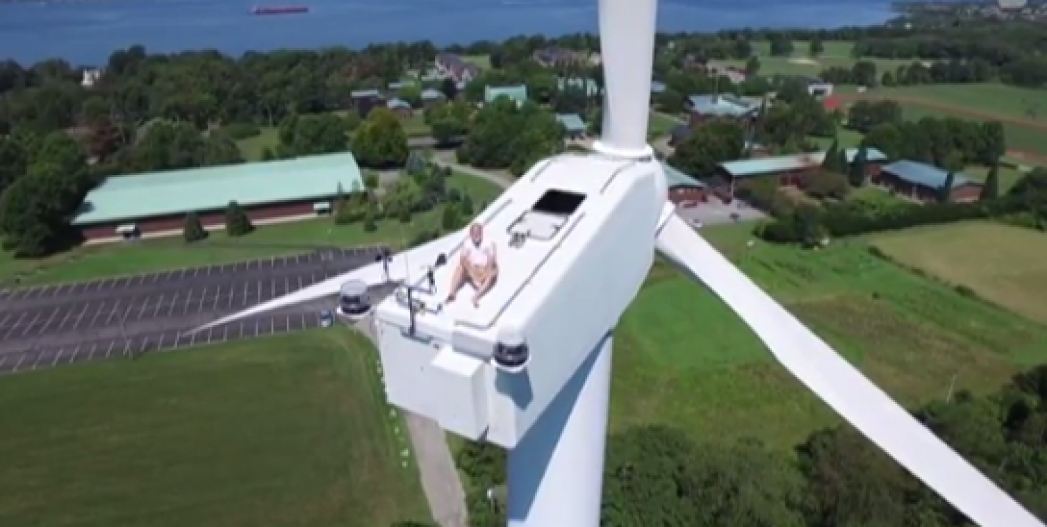 Man gaat zonnebaden bovenop een windturbine