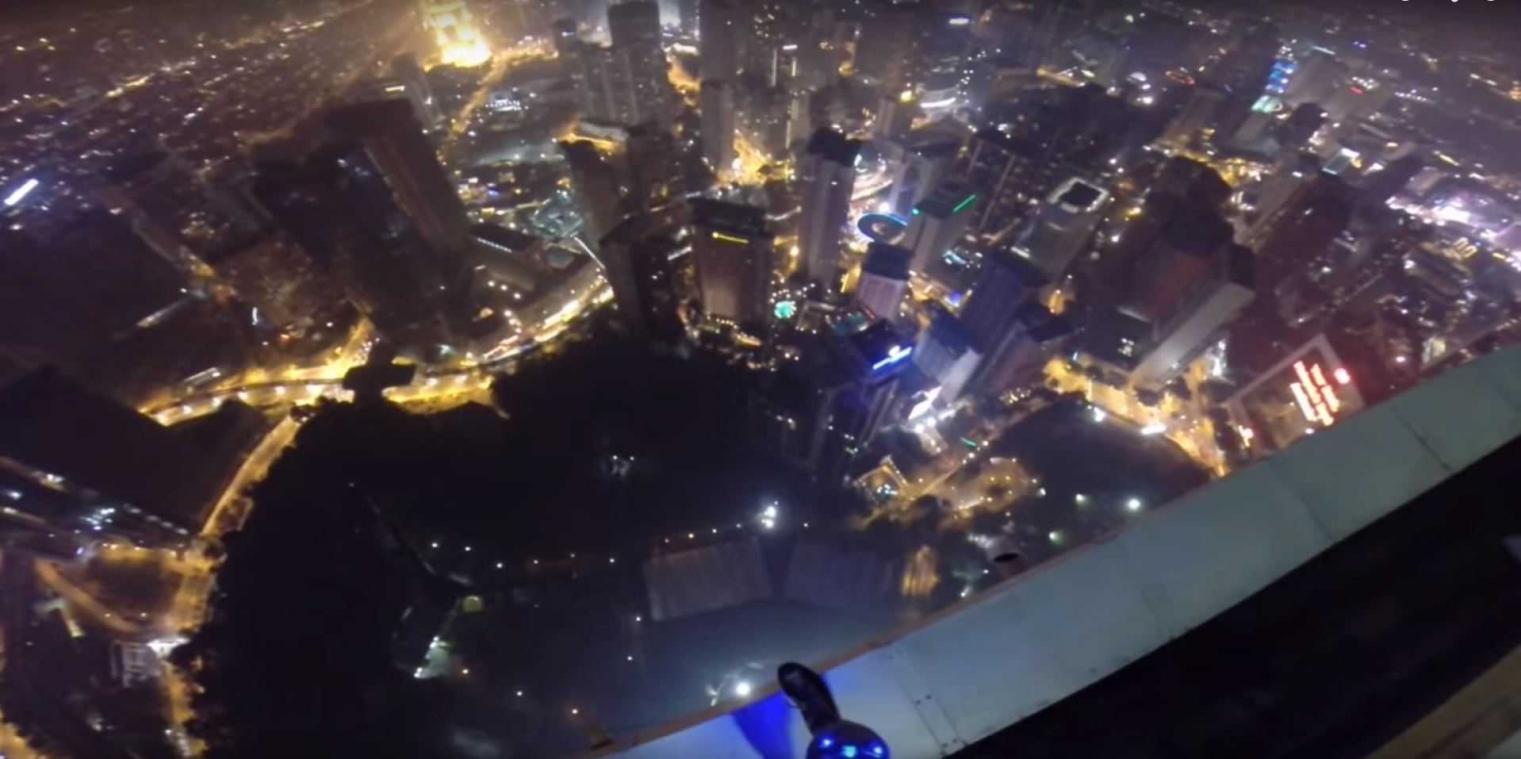 Basejumpers springen van een wolkenkrabber en landen in het zwembad, midden in een poolparty