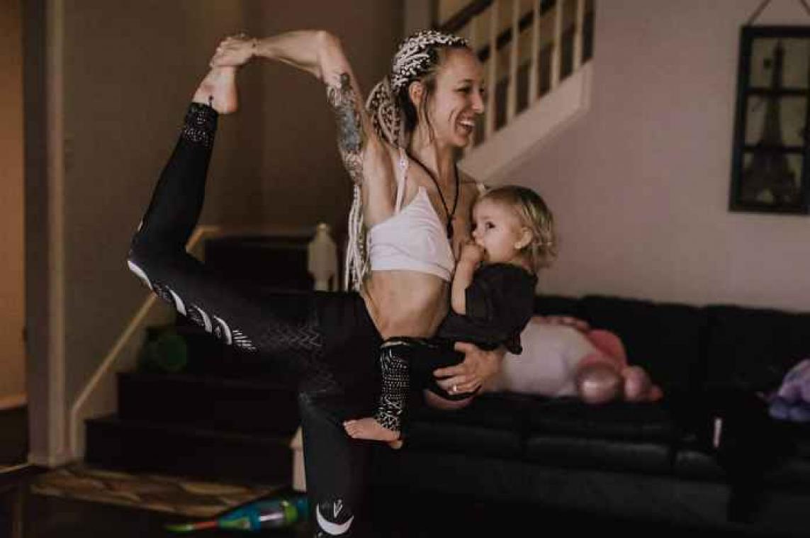 IN BEELD. Moeder geeft borstvoeding tijdens yoga