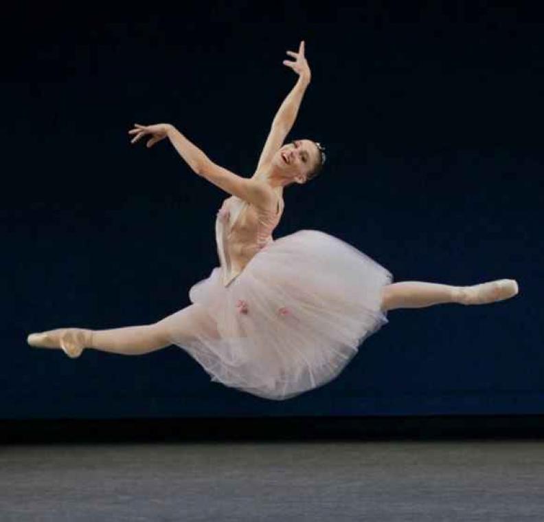 Zwangere ballerina straalt op spitzen