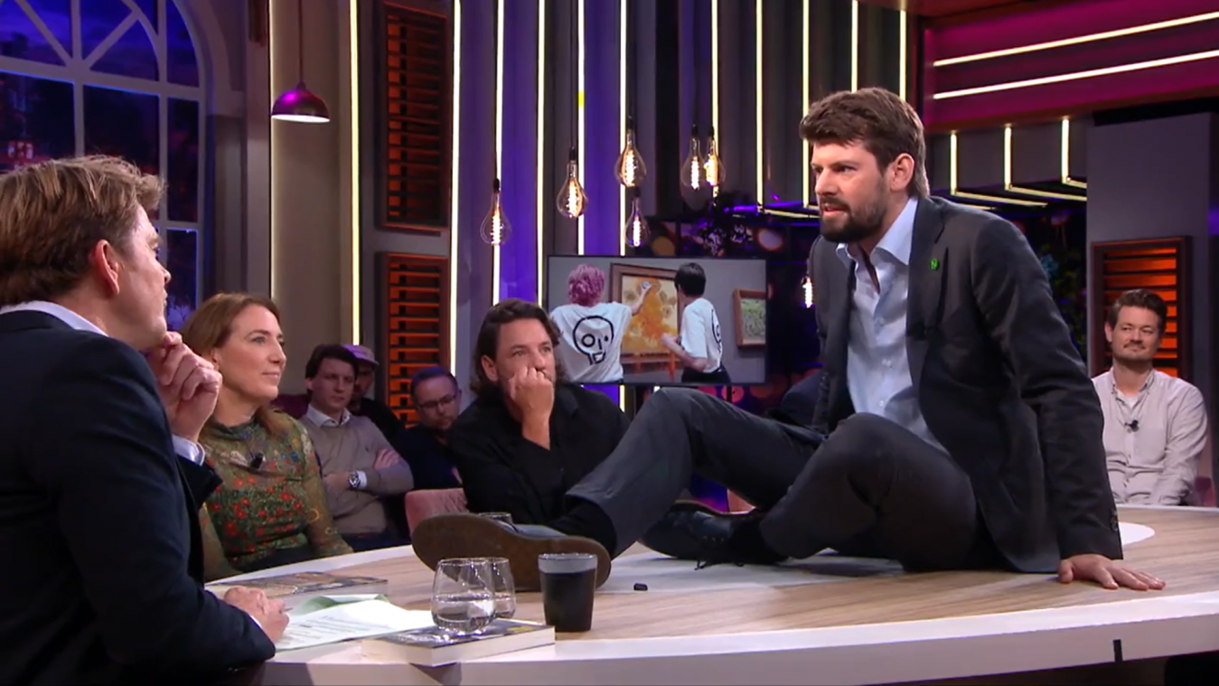 Klimaatactivist lijmt zich vast aan tafel tijdens Nederlandse talkshow Jinek (video)