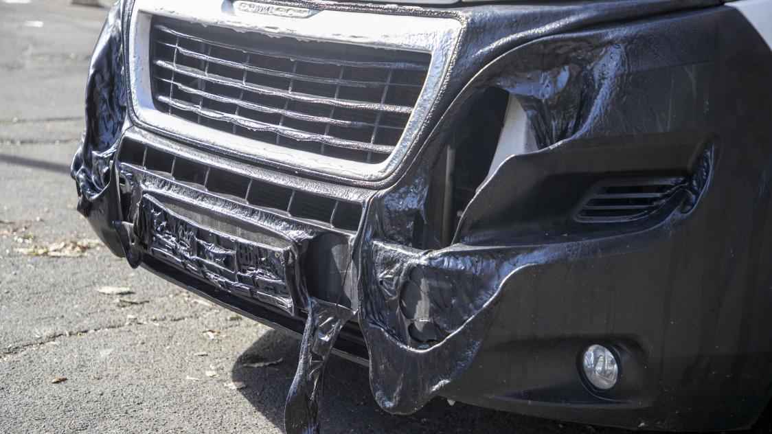 Foto van een beschadigde auto die op de plaats stond waar de auto van de daders uitbrandde.